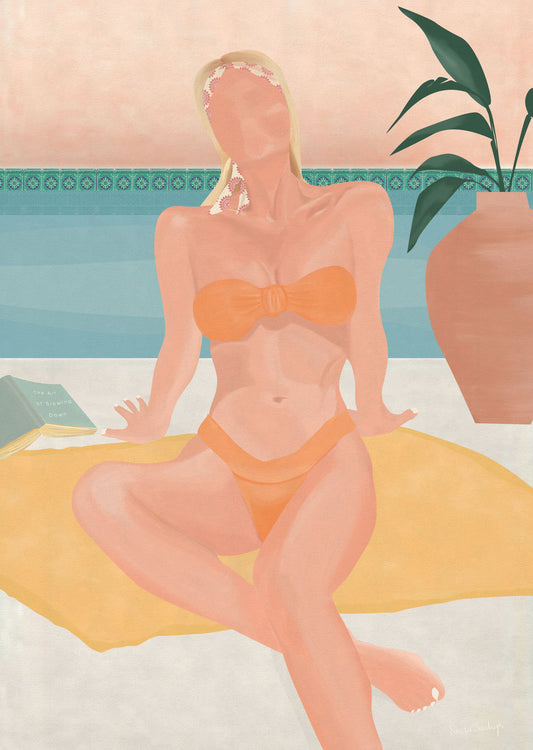 Woman in an orange bikini sitting on a towel by a poolside with a plant in the background.